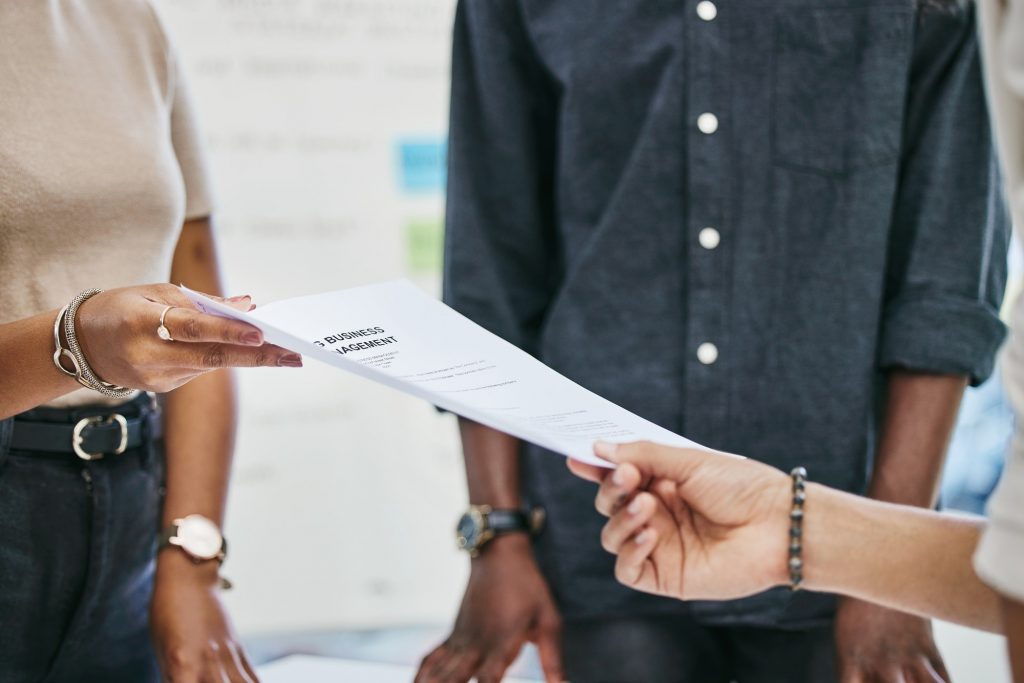 Please sign on the dotted line. Shot of businesspeople transferring documents.