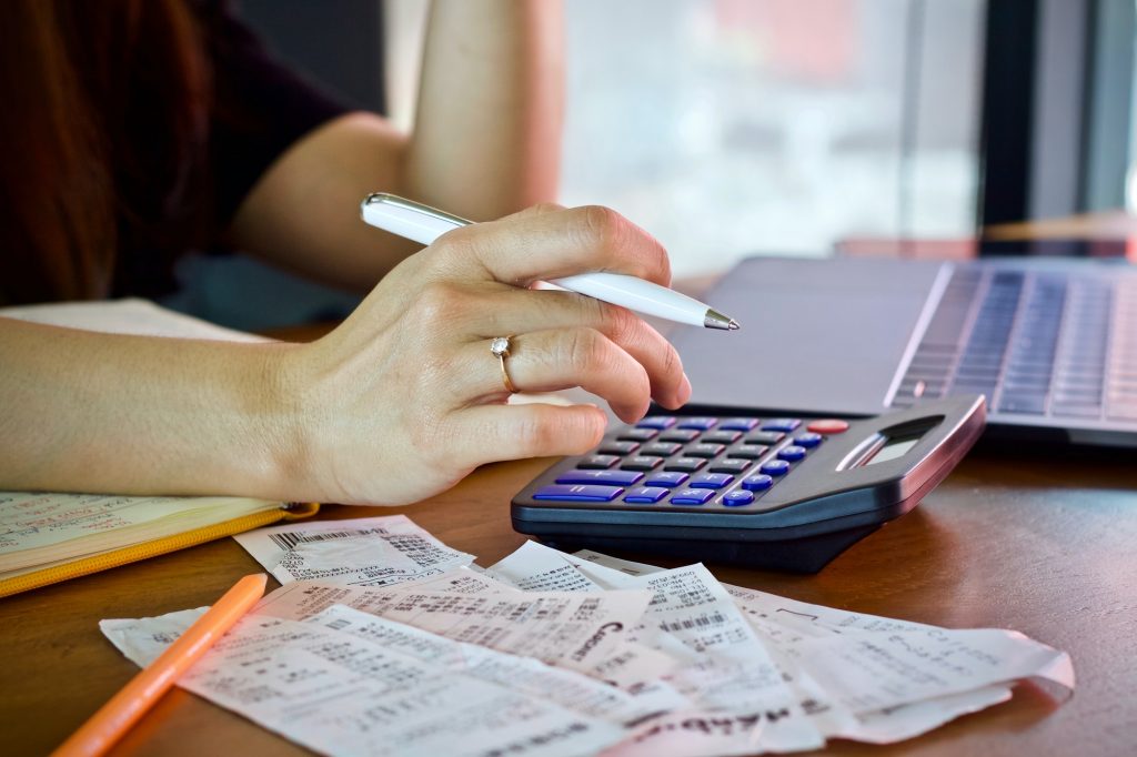 woman holding bill using calculator and calculate cost bill and payment
